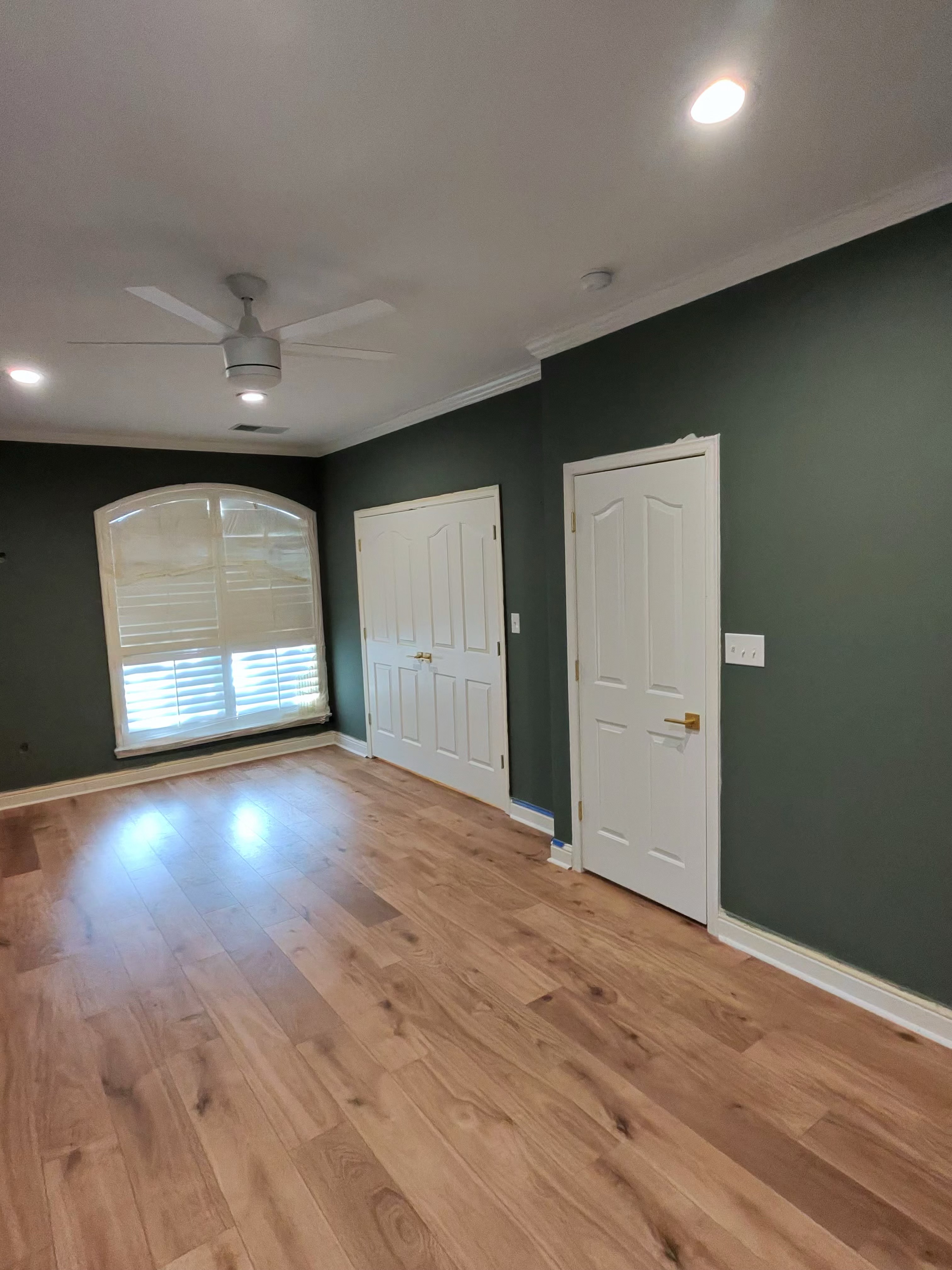 Finished green bedroom with hardwood